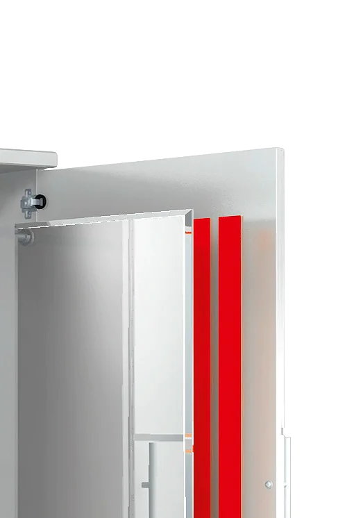 A close-up view of a partially open metal cabinet door with a gray finish. The interior reveals red vertical accents and a small latch mechanism near the top left corner of the door, secured with tesa tape. (This text has been generated by AI)