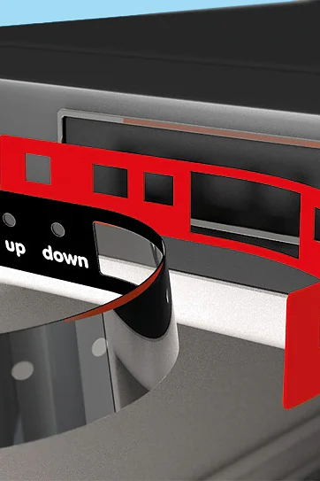 Close-up of a metal or plastic strip being inserted into a slot on the side of a device. The strip has labels: cooling, up, and down. Another red strip with square cutouts made from tesa tape is shown beside it. The background is light blue. (This text has been generated by AI)