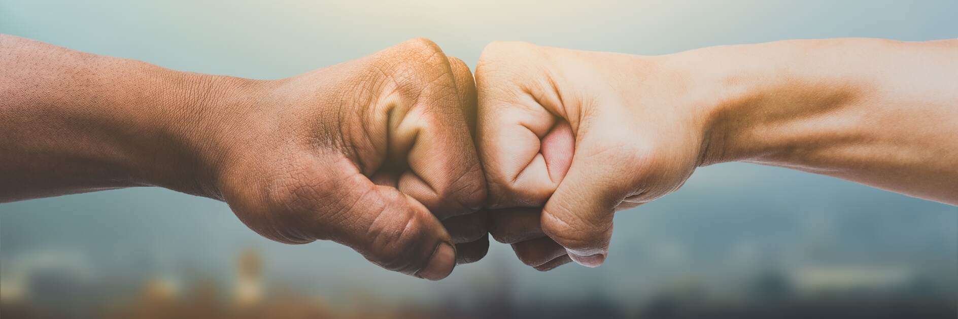 Man giving fist bump in sun rising nature background. power of teamwork concept. vintage tone