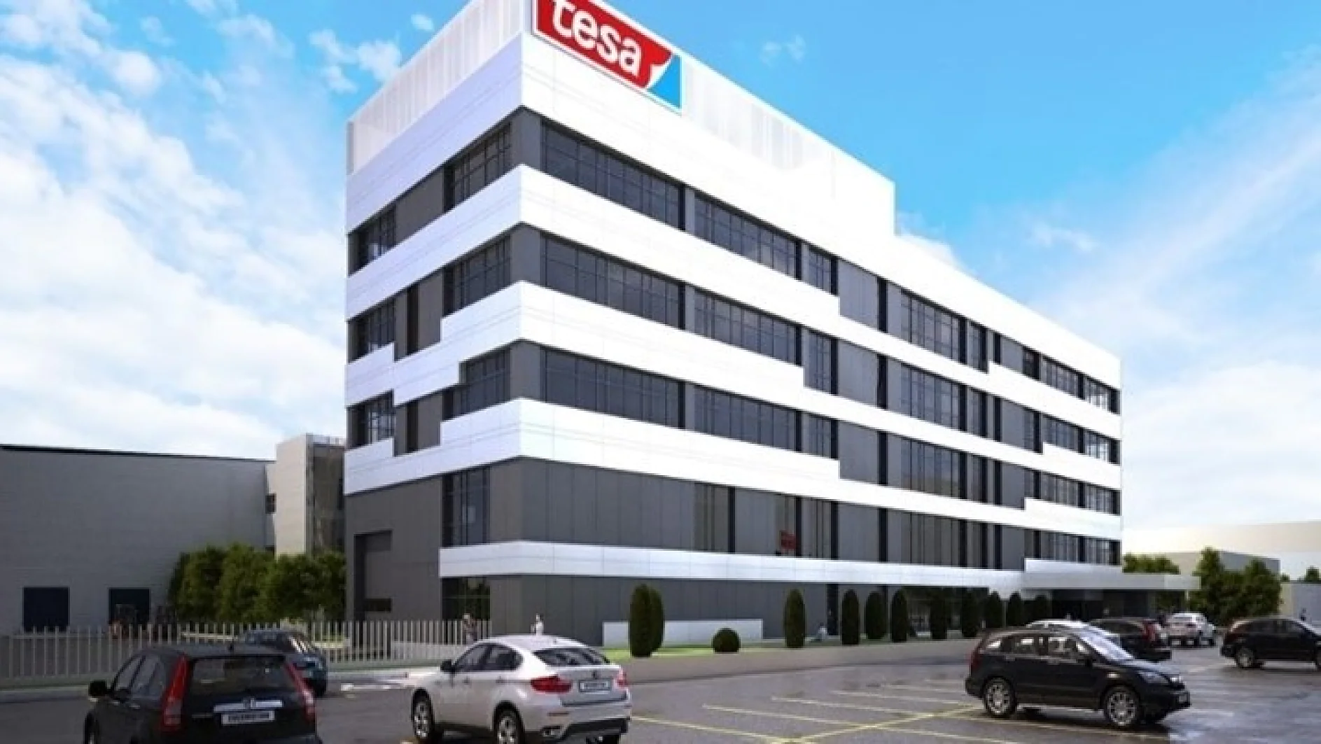 A modern, multi-story office building with a tesa logo on the top corner. The structure features a mix of white and dark horizontal panels. Several cars are parked in the lot in front of the building under a clear blue sky. (This text has been generated by AI)