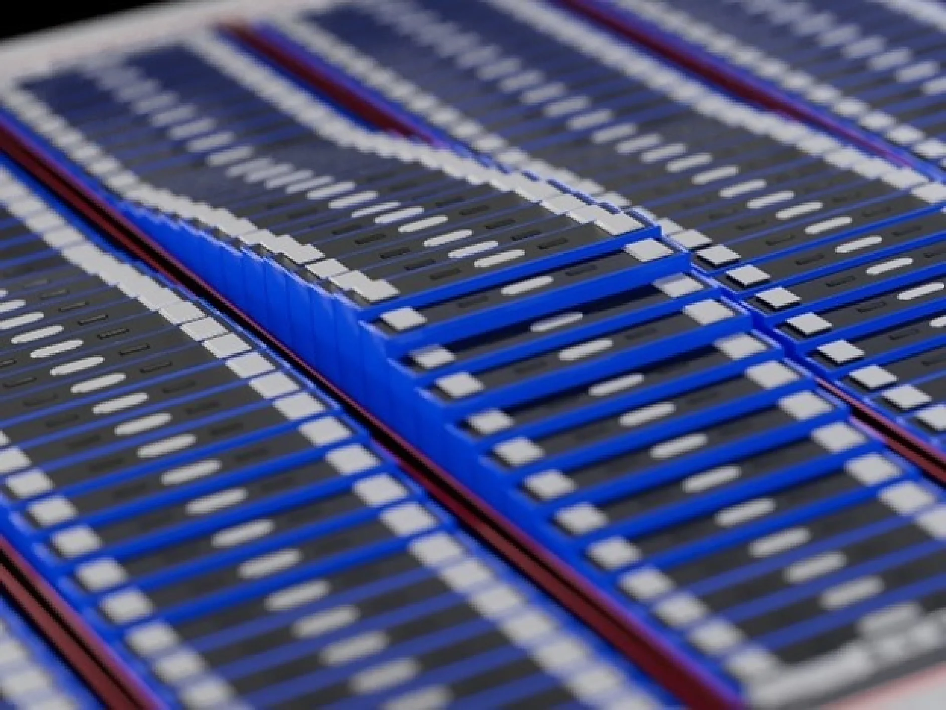 A close-up view of rows of smartphone screens stacked with a blue and black color scheme. The screens are aligned in a tilted, wave-like pattern across the surface, secured together with tesa tape. (This text has been generated by AI)